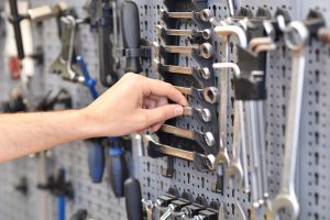 hand reaches for tools in a bicycle repair workshop